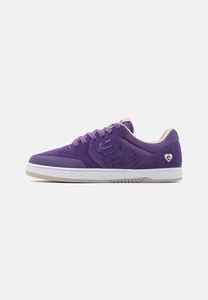 Fioletowy niski sneaker z cholewką ze skóry zamszowej i siateczki, perforowanymi bocznymi detalami, sznurówkami, białą podeszwą oraz logo w kształcie serca w pobliżu pięty.
