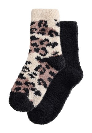 Dos pares de calcetines tobilleros mullidos: uno en color crema y rosa con manchas de leopardo negras y el otro completamente negro.