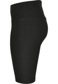 Jupe noire côtelée longueur genou avec taille haute, ajustée et texture lisse, vue de profil.