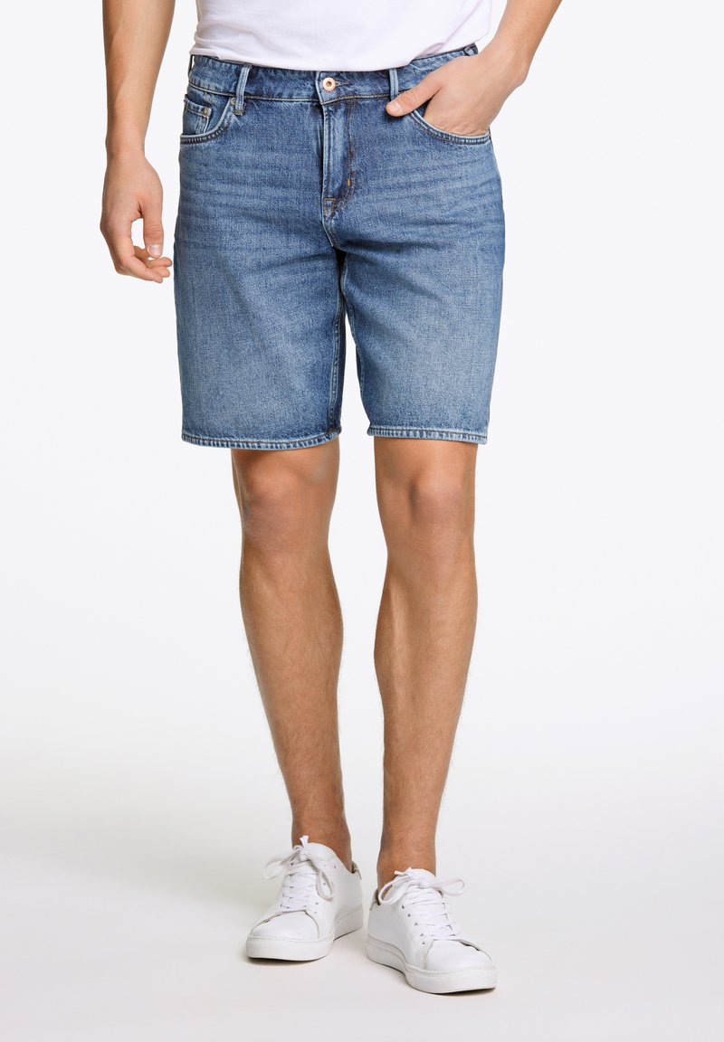 Denimshorts in middelblauwe wassing met een standaard pasvorm. Voorzien van voorzakken, gestikte accenten en een tailleband met een knoopsluiting.