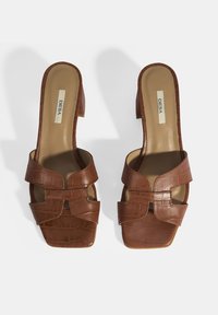 Bruine faux-krokodil leren sandalen met een vierkante neus en blokhak. Voorzien van brede banden met uitsnijdingen en een soepele binnenvoering.