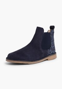Bocanci Chelsea din suede bleumarin cu panouri elastice pe laterale și un accent sclipitor pe călcâi. Dispune de o talpă din cauciuc pentru aderență și durabilitate.