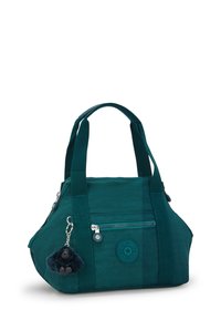 Teal fabric handbag with two short straps, zippered pocket, round logo patch, and furry gorilla charm attached to zipper.