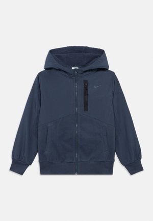 Casaco azul marinho com fecho éclair e capuz, forro em felpa, punhos elásticos, dois bolsos laterais e um bolso no peito com fecho de correr. Logotipo da Nike presente.