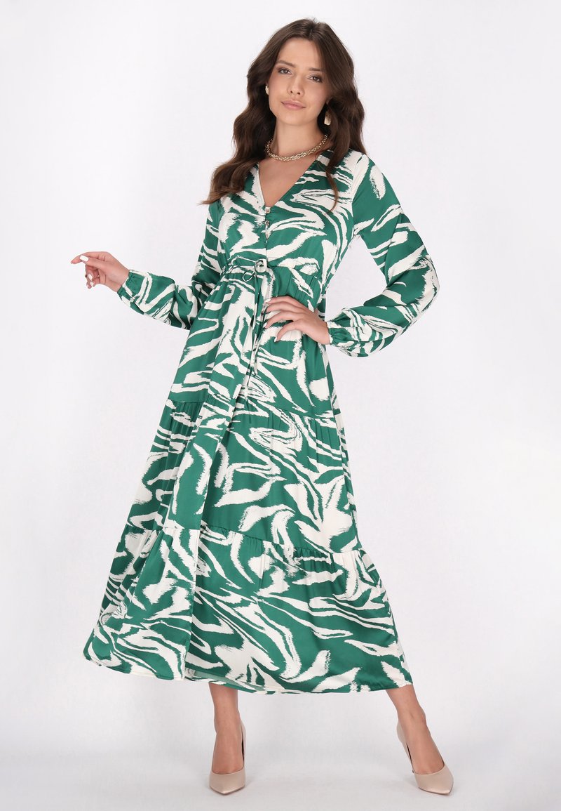 Rochie maxi cu un model verde și alb, cu decolteu în V, detalii cu nasturi, mâneci lungi și o curea ajustabilă la talie; material moale.