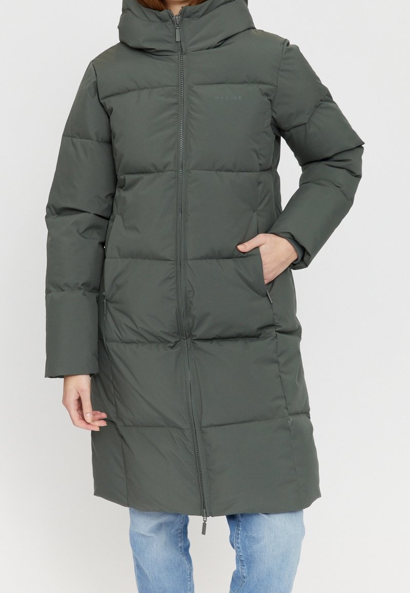 Manteau matelassé vert foncé avec capuche, doté d'une fermeture éclair frontale, de poches latérales et d'un design matelassé. Tissu texturé, longueur genoux.