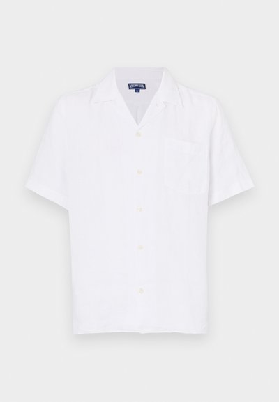 Camisa de botones de manga corta blanca, hecha de lino, con un clásico cuello de punta, bolsillo frontal y botones en beige claro.