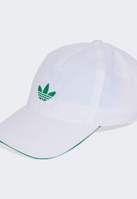 Witte pet van lichtgewicht stof, met een groen geborduurd logo met drie bladeren en een groene bies langs de klep.