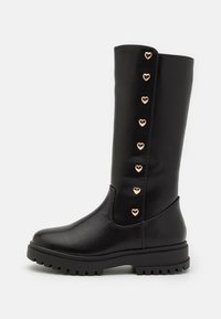 Bottes noires montantes jusqu'aux genoux en cuir synthétique, avec une semelle épaisse, une texture lisse et des accents décoratifs en forme de cœur rose doré.