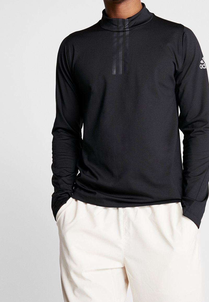 Schwarzes, langärmliges Sportoberteil mit hohem Kragen, das drei vertikale Streifendetails auf der Brust und eine glatte, strukturierte Oberfläche aufweist.