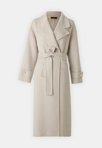 Trench coat beige realizzato in un morbido tessuto testurizzato. Caratterizzato da una vita con cintura, ampi risvolti e polsini con bottoni, dotato di tasche frontali.