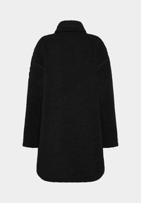 Svart, fluffig kappa med krage, långa ärmar och rak skärning. Strukturerad tyg utan synliga knäppningar eller dekorationer.