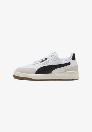 Weißer Sneaker mit schwarzen und beigefarbenen Akzenten, aus Leder und Wildleder, flacher Gummisohle und goldfarbenem PUMA-Logo an der Seite.