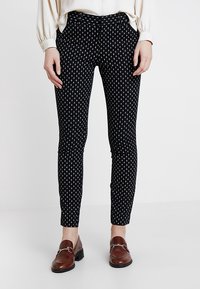 Pantalons noirs à motif avec un design en losanges en blanc et bleu, coupe slim, avec une texture lisse et une taille standard.