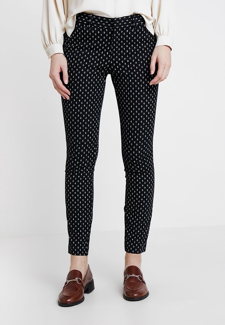 Pantalons noirs à motif avec un design en losanges en blanc et bleu, coupe slim, avec une texture lisse et une taille standard.