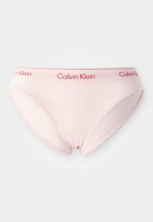 Lichtroze katoenen slip met een rode "Calvin Klein" logo op de tailleband. Glad oppervlak, klassiek ontwerp en standaard pasvorm.