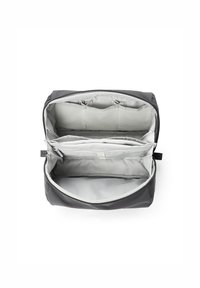 Grau gestreifter Reisetasche mit mehreren Fächern, einem glatten Reißverschluss und einem weichen Innenfutter. Verfügt über elastische Bänder zur Organisation.