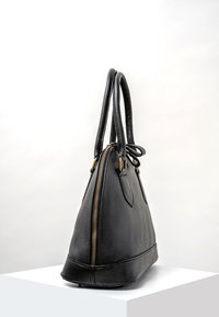 Borsa a mano in pelle nera con superficie texturizzata, forma triangolare, due manici lunghi e dettagli con zip dorata lungo il lato.