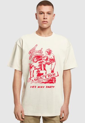 Cream-colored cotton oversized T-shirt with red graphic print featuring stylized text and figures, round neckline and short sleeves.