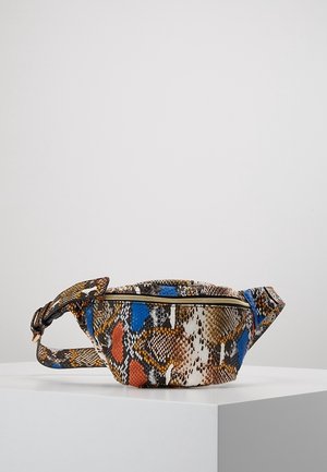Sac banane avec un motif de peau de serpent multicolore comprenant des écailles bleues, orange, marron et blanches, fermeture éclair dorée et sangle ajustable sur une surface blanche.