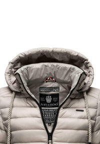 Beige puffer jacket with a drawstring hood, black zipper, and contrast interior. Features branding tags and a quilted texture.