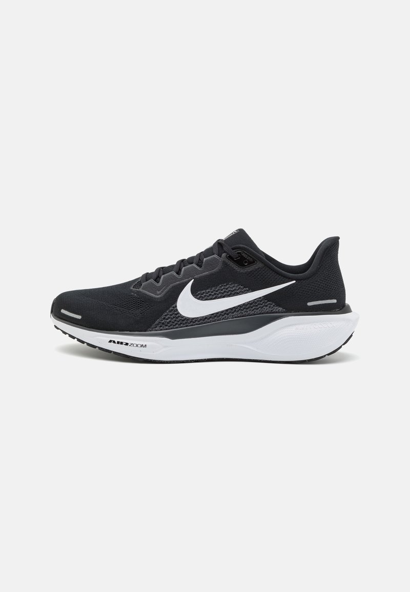 Chaussure de running Nike noire avec logo swoosh blanc, semelle intermédiaire blanche et semelle extérieure noire, vue de l'intérieur.