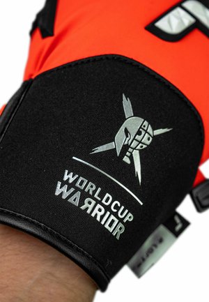 Black and orange sports glove with a textured black wrist section. Features a silver logo with a warrior motif and "WorldCup Warrior" text.