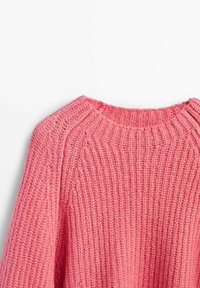 Maglione rosa lavorato a maglia con texture a coste, collo rotondo ampio e spalle scese. Il tessuto sembra morbido e spesso, adatto a climi più freschi.