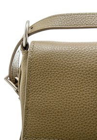 Borsa a tracolla in pelle beige con superficie testurizzata, dotata di una tracolla robusta e accessori in metallo. La vista angolata mette in risalto la forma e le cuciture della borsa.