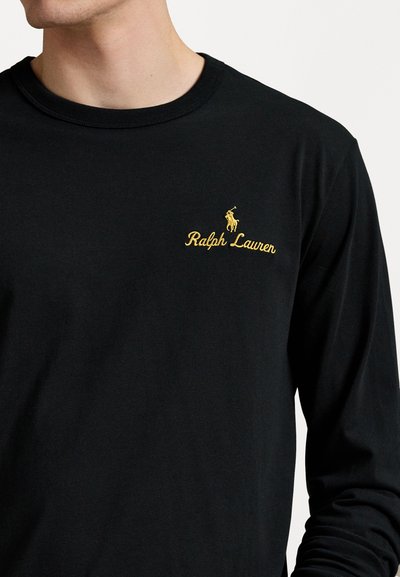Melns garām piedurknēm T-krekls, izgatavots no mīksta kokvilnas, ar dzeltenu izšūtu zirglogo un "Ralph Lauren" tekstu kreisajā krūtī.