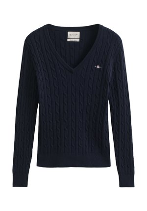 Džemper tamnoplave mornarske boje s pletenim uzorkom u kabel stilu, V-izrezom, rebrastim manžetnama i rubom. Na prsima je uvezeni GANT logo. Tkanina s teksturom.