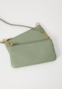 Borsa a tracolla in pelle verde chiaro con superficie testurizzata, dotata di due scomparti con zip e dettagli metallici dorati.