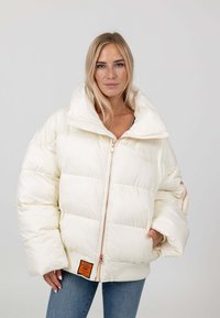 Pufferjack in off-white, met een hoge kraag, ritssluiting en geribde manchetten. Opvallend oranje etiket aan de zoom.
