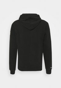 Sweat à capuche noir à manches longues, poignets et ourlet côtelés, en tissu doux, avec un patch logo sur la manche gauche.