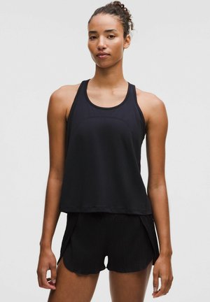 Svart atletisk linne med rund halsringning, ärmlös design och en avslappnad passform. Matchat med texturerade svarta shorts.