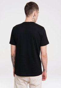 Sort bomulds T-shirt med korte ærmer og rund hals, der har en glat tekstur og ingen dekorative elementer, vist bagfra.