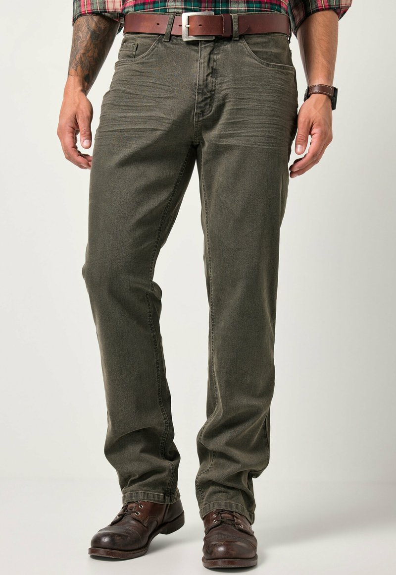 Pantaloni dritti color verde oliva realizzati in tessuto resistente, dotati di cinque tasche e dettagli in metallo, abbinati a stivali in pelle marrone.
