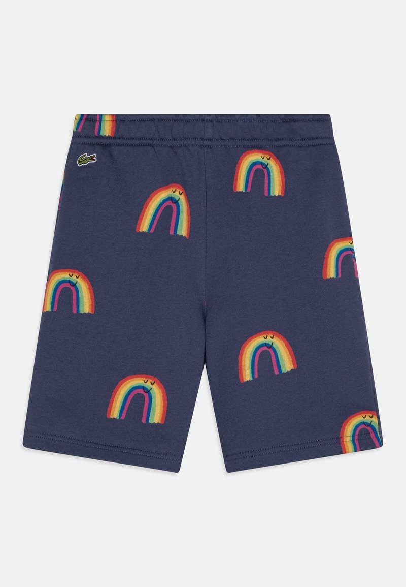 Short bleu marine avec taille élastique, décoré de motifs arc-en-ciel souriants et d'un petit logo crocodile vert près de la taille.