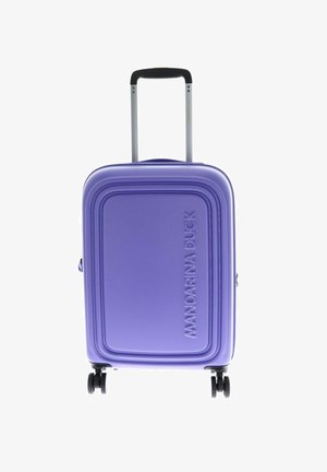 Valise rigide violette avec une surface texturée et un logo en relief. Dispose d'une poignée télescopique et de quatre roues pour la mobilité.