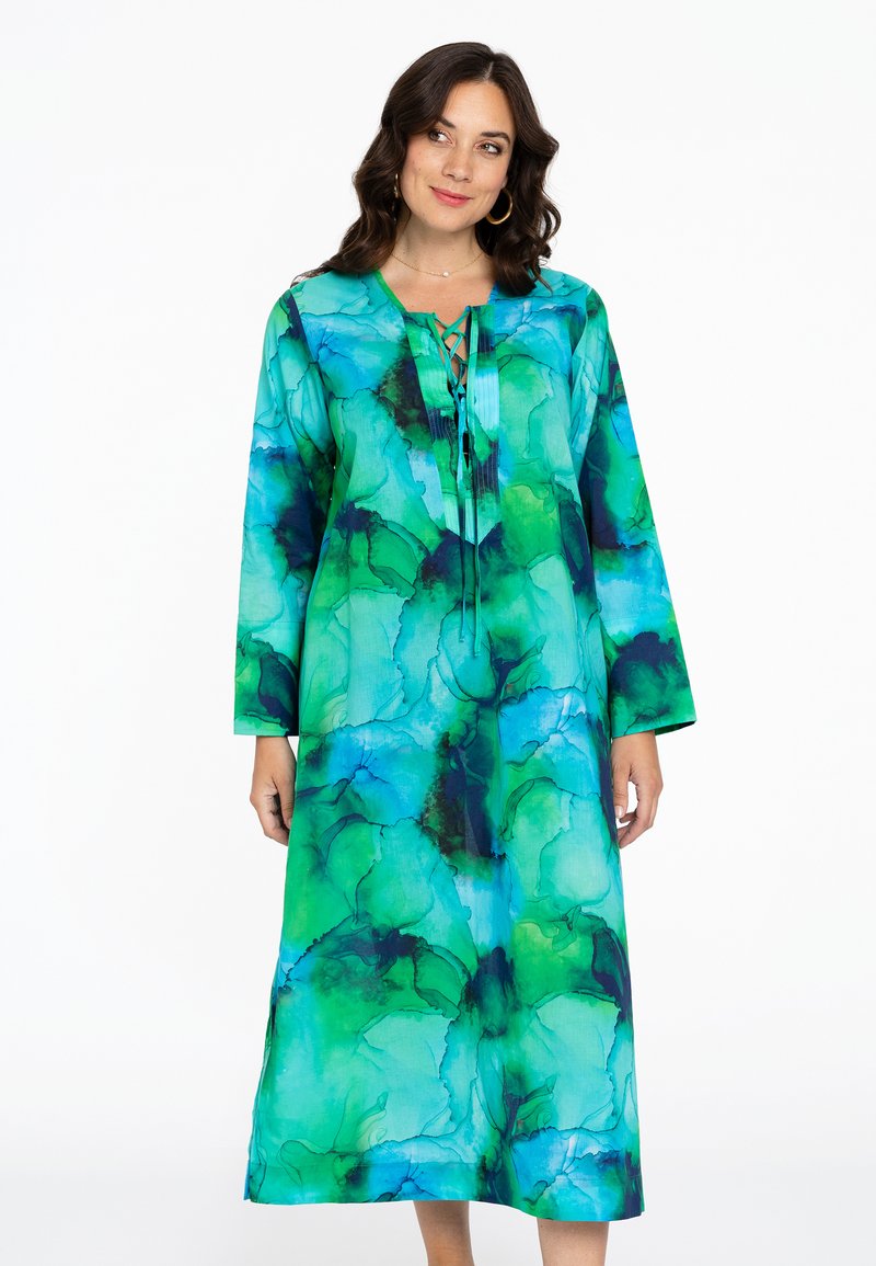 Lang, vloeiende jurk met een levendig blauw en groen abstract patroon, met een V-halslijn en strikdetail aan de voorkant.