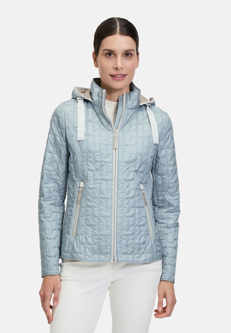 Hellblau gesteppte Jacke mit Kapuze, ausgestattet mit weißen Riemen, doppelten seitlichen Reißverschlusstaschen und einem Reißverschluss vorne. Glatte Textur und taillierte Passform.