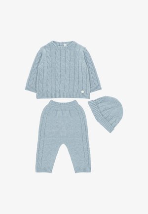 Un conjunto de tres piezas de color azul claro, que incluye un suéter de punto trenzado, pantalones a juego y un gorro. Presenta puños acanalados y un botón decorativo.