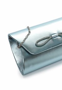 Pochette bleue métallisée avec fermeture à rabat, bandoulière chaîne argentée et détail décoratif en boucle à l’avant sur fond blanc.