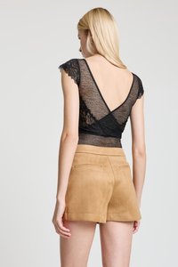 Haut en dentelle noire à manches courtes, avec un profond décolleté en V à l'arrière. Associé à un short en daim beige, offrant une texture lisse et une coupe ajustée.