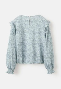 Ljusblå blus med lång ärm, volangdetaljer på axlarna, smockade ärmslut och en nyckelhålsdetalj i ryggen. Har ett paisleymönster. Tyg av bomullsblandning.