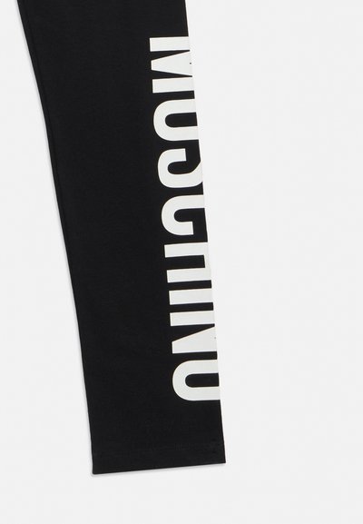 Mustriline valgel stiliseeritud tekstiga must kangas, kus serva mööda on osaliselt nähtaval tähed "MUCUUIN".