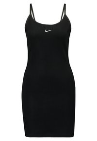 Svart ribbad klänning med tunna band, försedd med en liten vit Nike-logga centrerad på bröstet. Kroppsnära design med rak skärning.