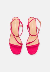 Rosa mockaskinnsandaler med en minimalistisk design som har två tunna remmar och en låg blockklack. Guldtonad hårdvara och en slät innersula.