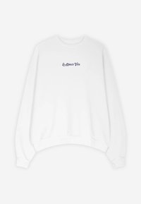 White sweatshirt with a rounded neckline and dropped shoulders. Features navy text "La Dolce Vita" on the chest. Soft cotton fabric.