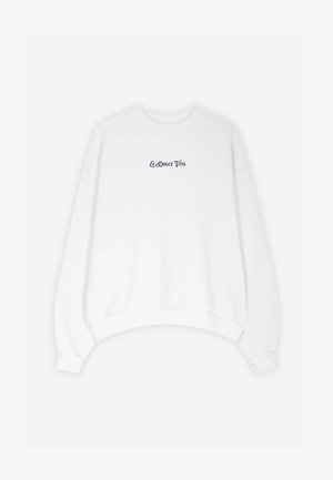 Bijela dukserica s zaobljenim izrezom i spuštenim ramenima. Sadrži tamnoplavi natpis "La Dolce Vita" na prsima. Mekana pamučna tkanina.